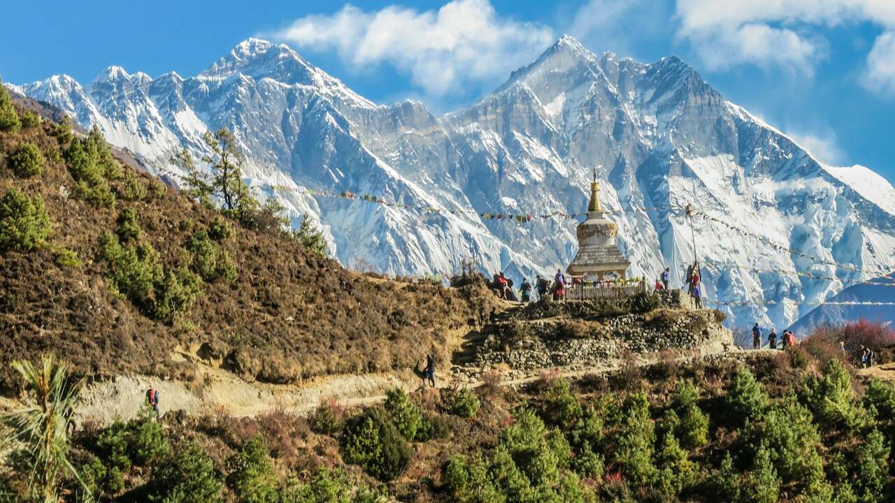 A stupa with prayer flags below the Himalayan peaks