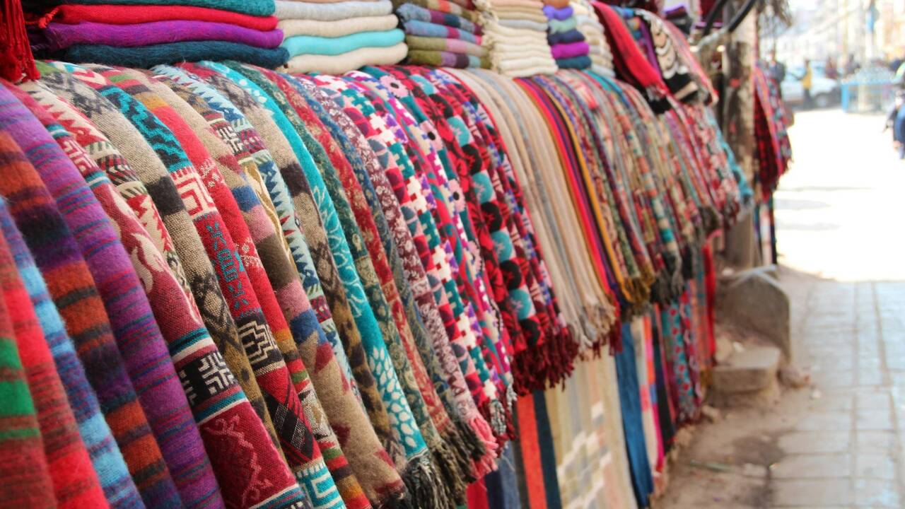 Colourful handwoven scarves hanging at a market stall
