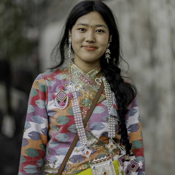A young woman in a handwoven Nepali top with silver jewellery